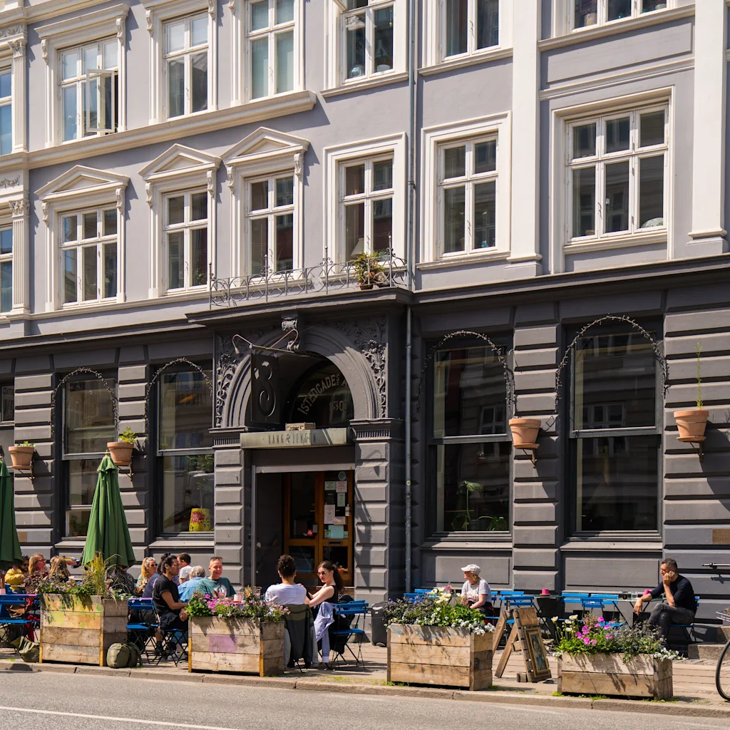 People enjoying outdoor seating at a cafe on Istedgade on Vesterbro in Copenhagen.