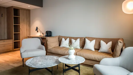 En koselig og moderne Juniorsuite på Quality Airport Hotel Værnes, med komfortabel sofa, lenestoler og en arbeidsplass.