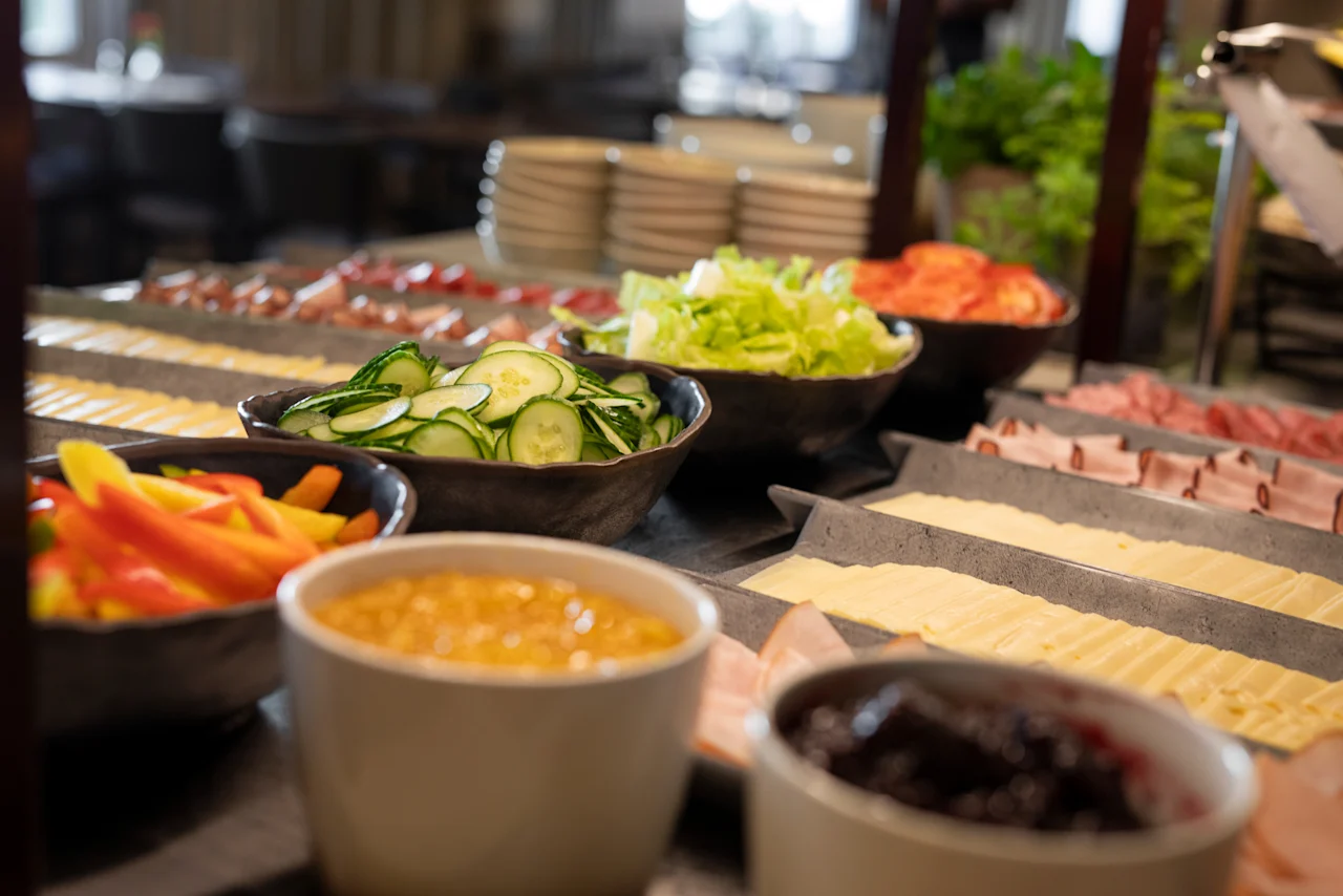 En inbjudande frukostbuffé med en mängd färska ingredienser inklusive grönsaker, ostar och kallskuret.