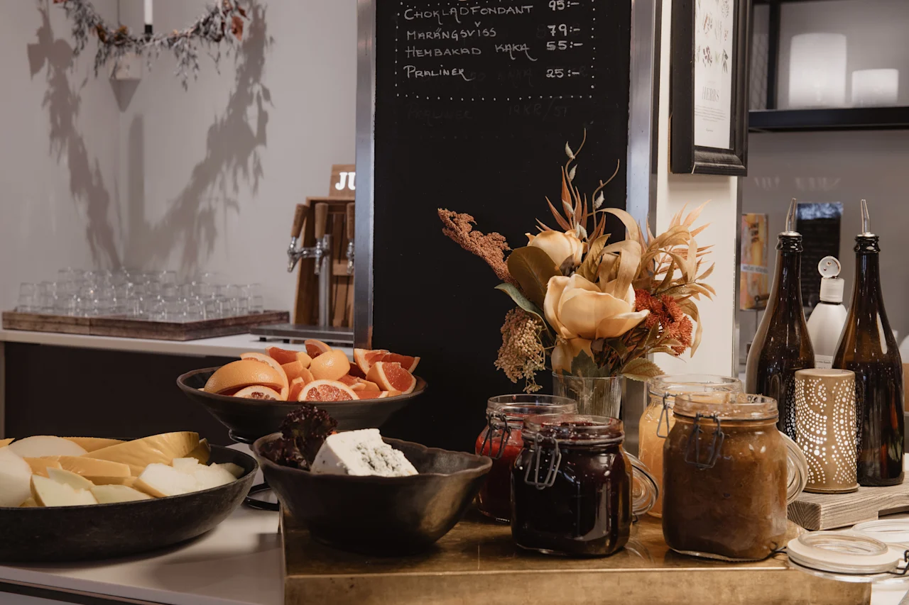 En buffet med forskellige madvarer og en dessertmenu: CHOKLAD FONDANT 95, MARANGSVISS 79, HEMBAKAD KAKA 55.