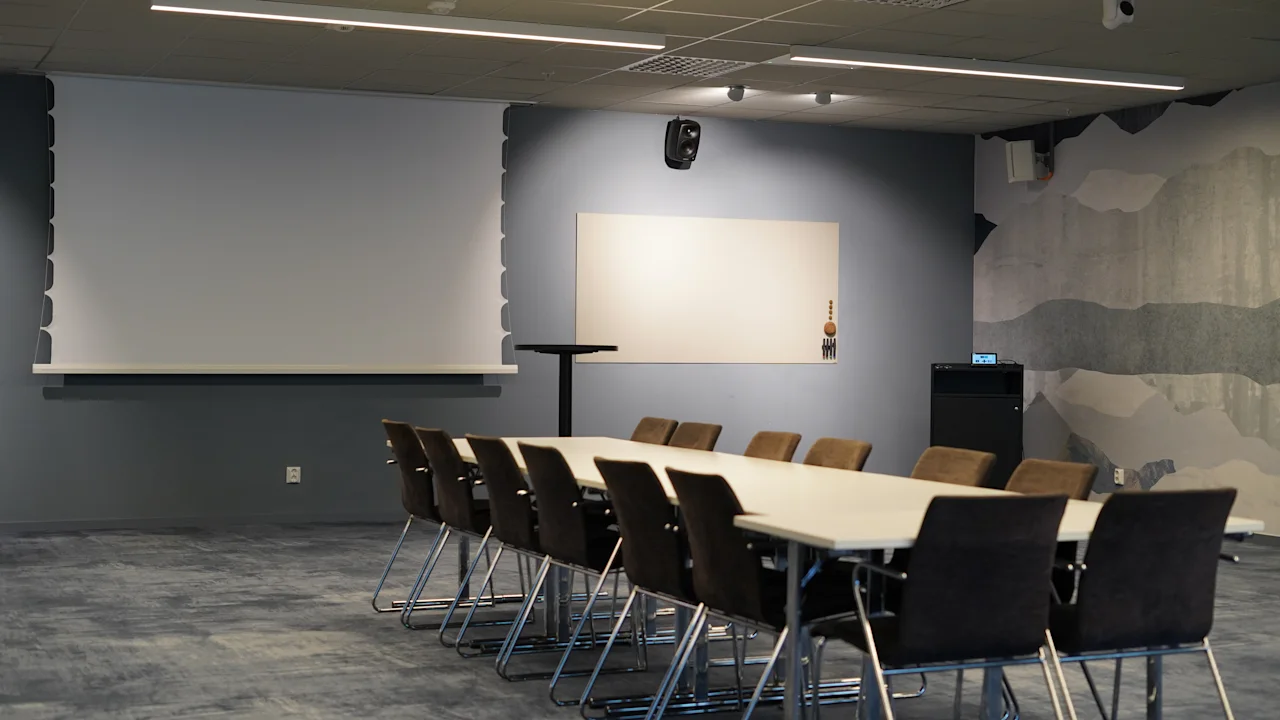 Et velutstyrt konferanserom på Quality Hotel Arlanda XPO, klart for presentasjoner og samarbeidsmøter.