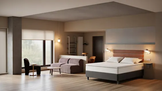 A modern hotel room with a comfortable bed, a cozy seating area, and a large window offering a view of nature.