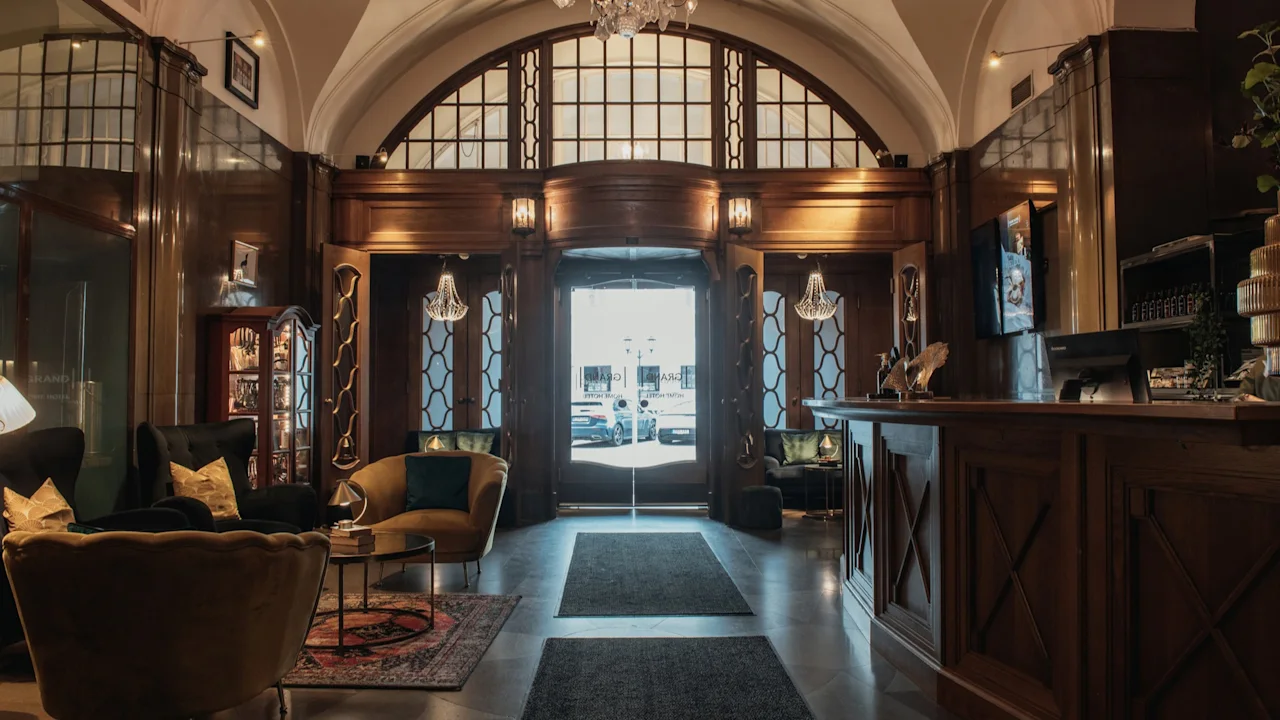 Elegant hotellobby med en storslått inngang, resepsjon og komfortable sittegrupper på Home Hotel Grand, Helsingborg.