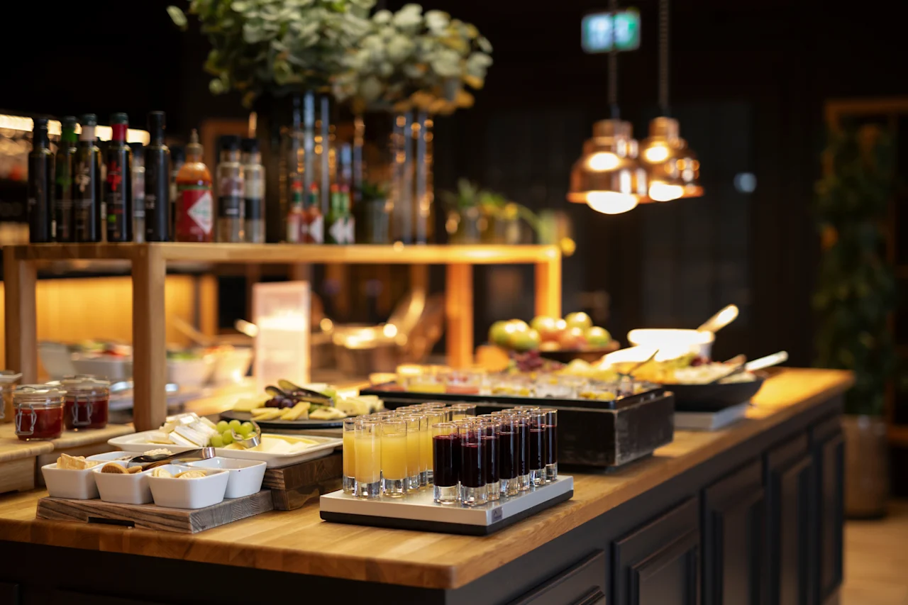 Et livligt buffetbord fyldt med et udvalg af morgenmadsvarer, inklusive juicer, oste og krydderier.