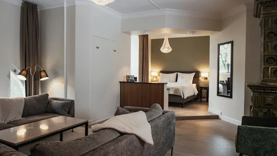 En romslig hotellsuite på Home Hotel Norre Park med et komfortabelt oppholdsrom og et koselig soverom.