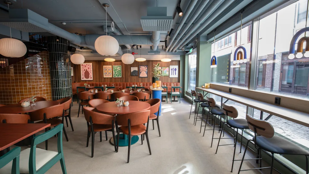 Comfort Hotel City Göteborg. Et moderne restaurantinteriør med runde borde, komfortable stole og et lyst vinduesbarområde.