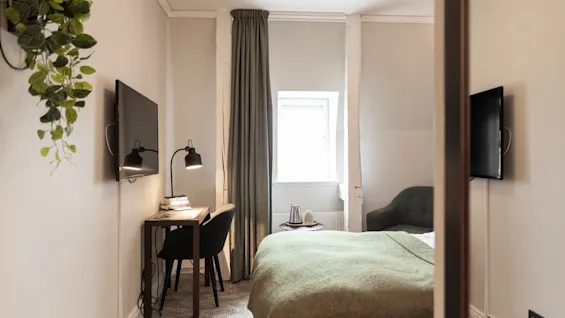 Home Hotel Victoria: Kutsuva hotellihuone, jossa on mukava sänky, käytännöllinen työpöytäalue ja seinälle asennettu televisio vieraille.