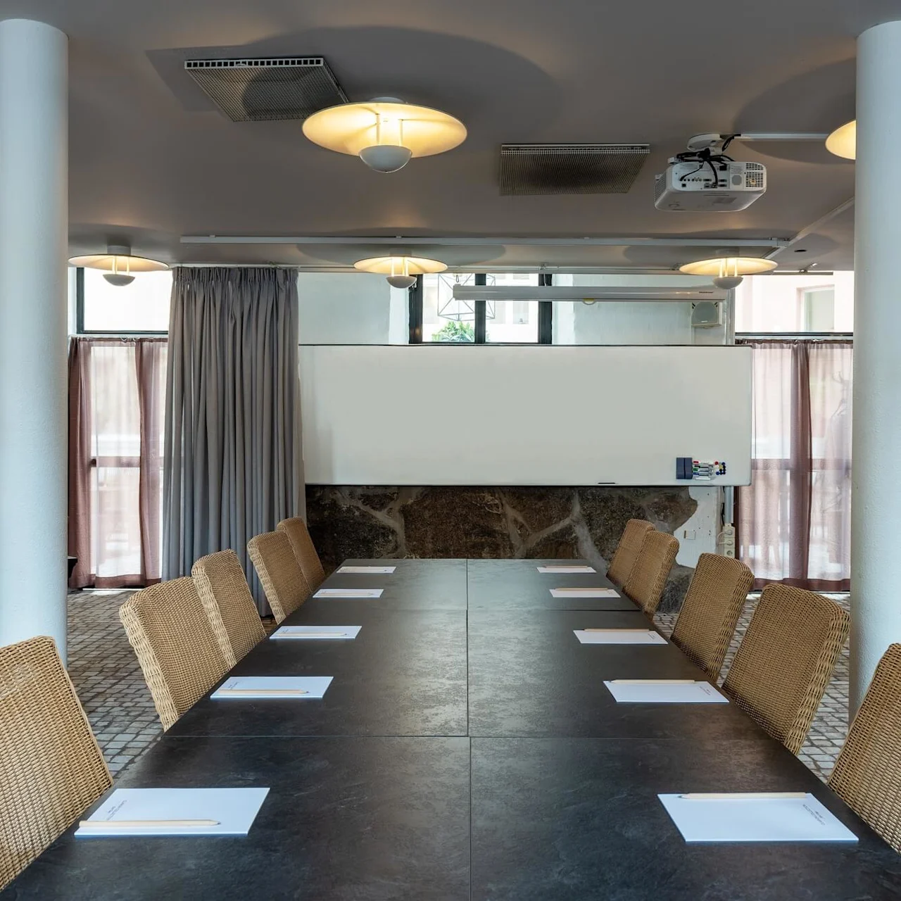 Ett konferensrum med långt bord, stolar och presentationsteknik; redo för ett möte.
