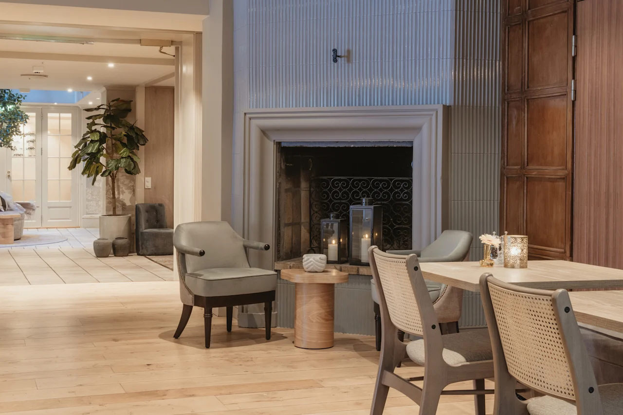 En varm och inbjudande hotellounge med öppen spis, bekväma sittplatser och mjuk belysning från levande ljus.