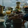 People enjoying breakfast around a table filled with juice, coffee, and bread.