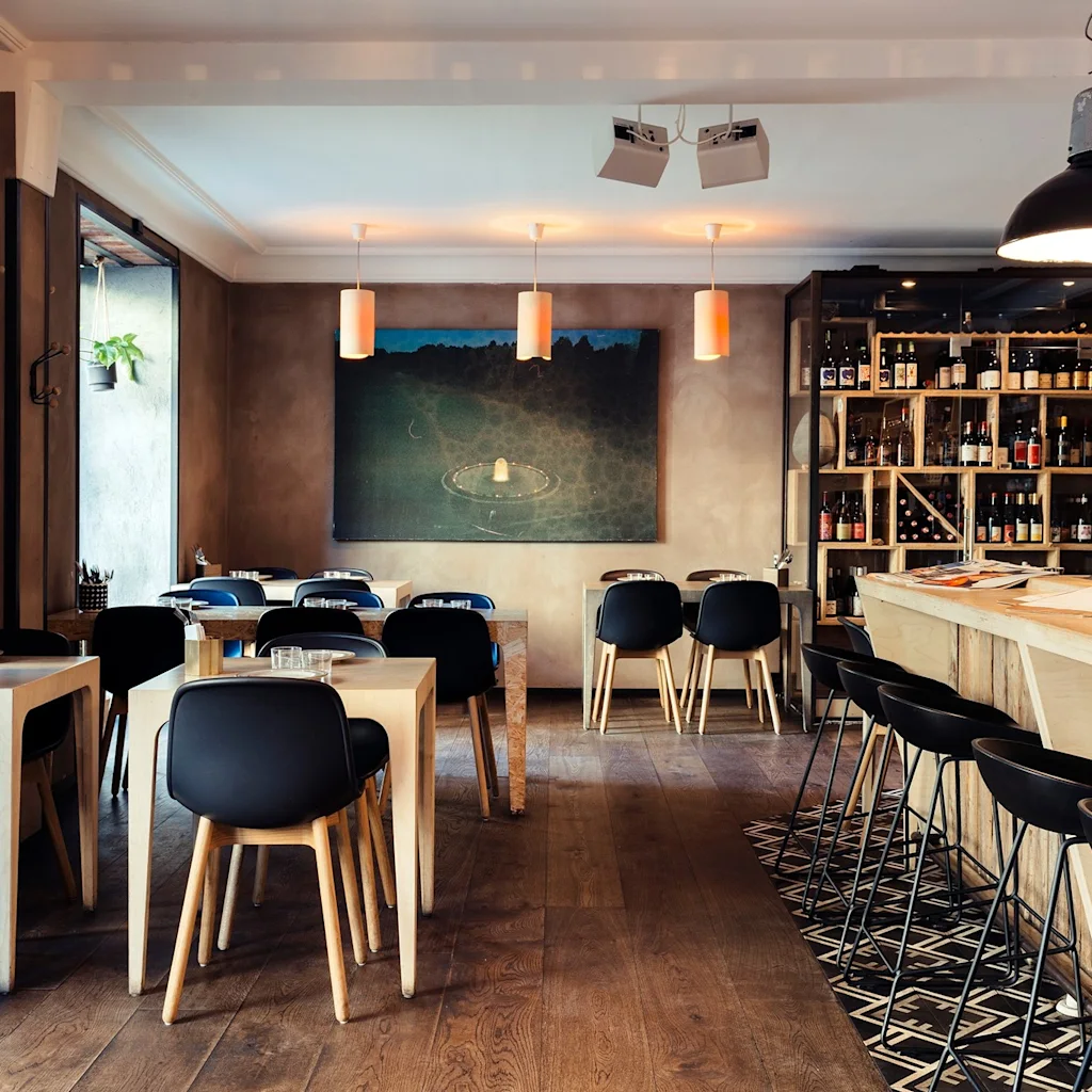 En indbydende restaurant med moderne træmøbler, en velassorteret bar og varm stemningsbelysning for en behagelig spiseoplevelse.