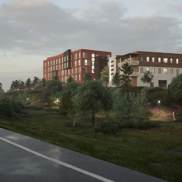 En moderne hotelbygning med et HOTEL-skilt, set fra en vej. Folk går og cykler i et grønt parkområde.