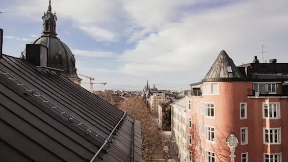 Home Hotel Wellington. En byudsigt ovenfra, med historisk arkitektur og et levende bylandskab under en skyet himmel.