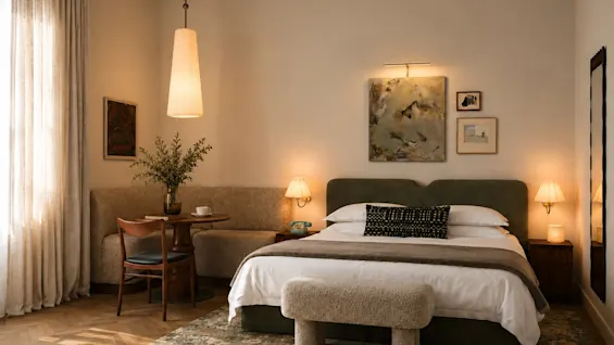 Ett mysigt hotellrum med säng, liten matplats och varm belysning. Våra rum tar fortfarande form visualiseringar inte fotografier.