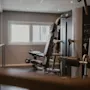Moderni kuntosali, jossa on monitoiminen kuntosalilaite ja ikkuna taustalla.
