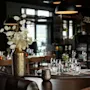Et koselig restaurantinteriør med dekkede bord, elegant innredning og varm belysning, klart for gjester.