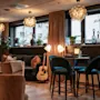 Home Hotel Grand Bodø: A cozy and inviting hotel lounge with comfortable seating, warm lighting, and a relaxed atmosphere.