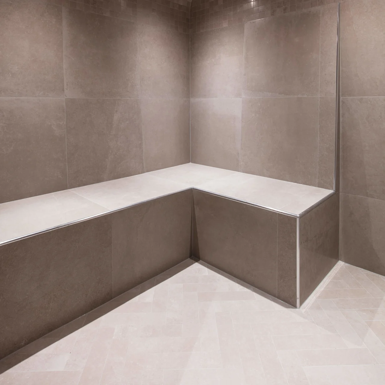 A tiled steam room with bench seating and ceiling lights.