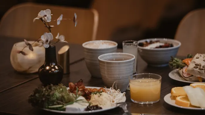 Et bord dekket med en deilig frokostbuffé, inkludert kaffe, te, juice og ulike retter, på Home Hotel Norre Park i Halmstad.