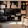 En indbydende hotellounge med en stor skærm, integrerede hylder fyldt med bøger og indretning samt komfortable siddepladser.