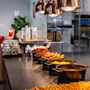 A warm and inviting breakfast buffet at Comfort Hotel Vesterbro, offering a variety of hot dishes under stylish pendant lights.