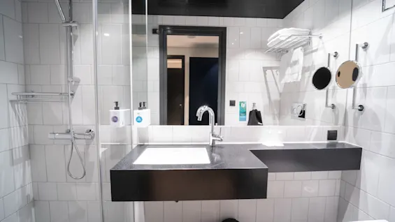 Et lyst og moderne hotellbad på Quality Hotel Strawberry Arena, med dusj, servant og rene håndklær.