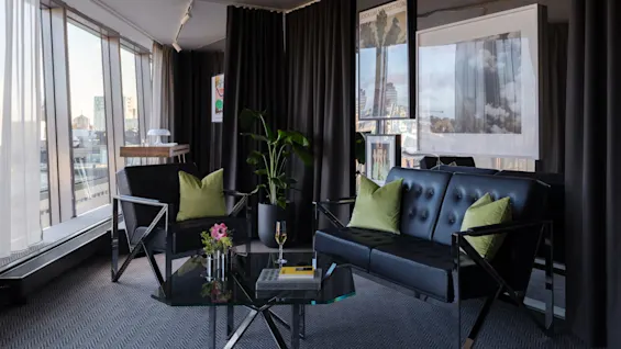 Tyylikäs oleskelutila, jossa mustat nahkaistuimet, vihreät tyynyt ja kaupunkinäkymät. Lisää Stratum Suite Clarion Hotel Signiin Tukholmassa.