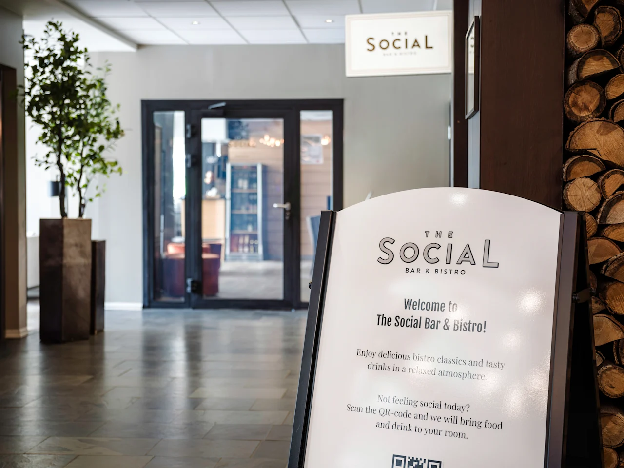 A sign for a bar and bistro, inviting guests to enjoy food and drinks in a relaxed atmosphere or order to their room.