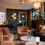 A stylish and inviting hotel lounge at Home Hotel Grand Bodø, featuring comfortable seating, warm lighting, and modern decor.
