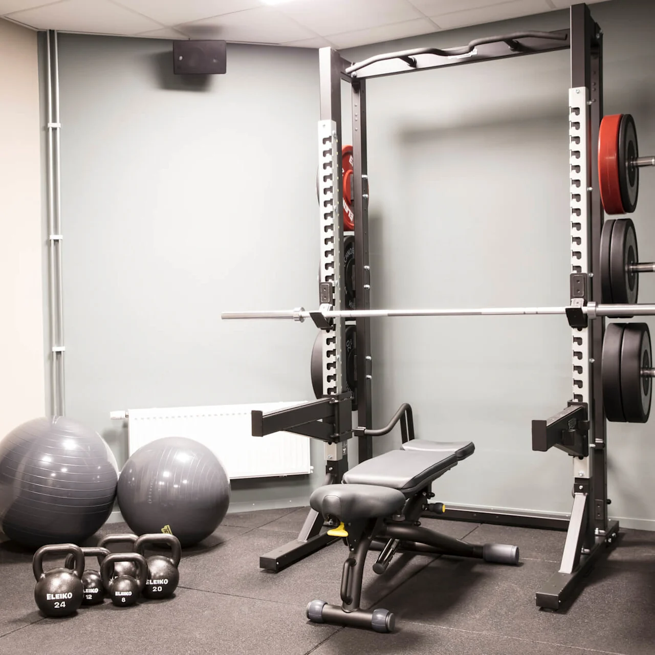 A gym with weights, a bench, and exercise balls, ready for strength training.