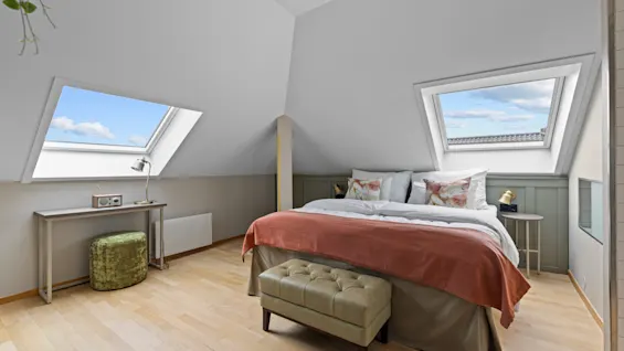 Et lyst loftssoverom på Home Hotel Gabelshus med en stor seng, to takvinduer og lyse tregulv.