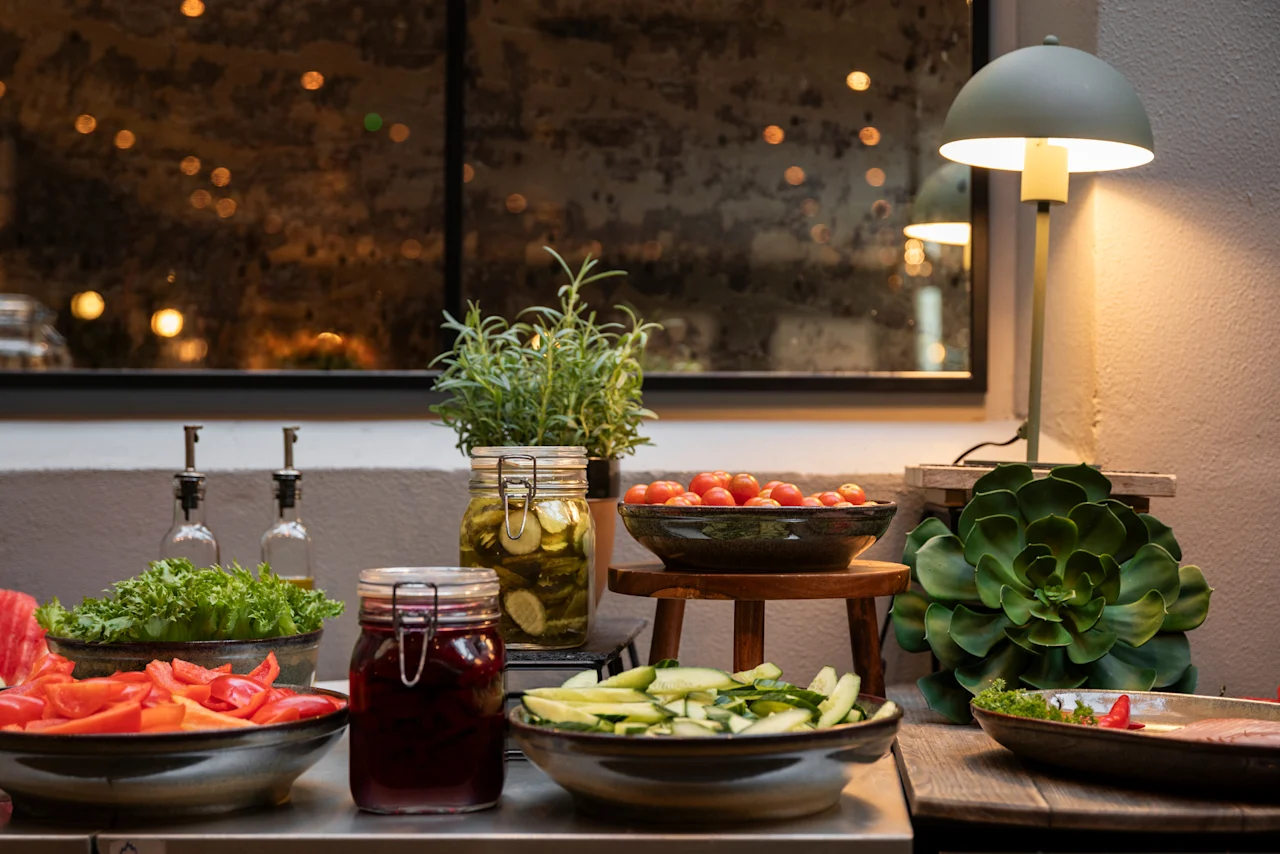 A vibrant buffet spread featuring fresh vegetables, pickled items, and condiments, ready for guests at Home Hotel Grand Bodø.