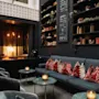 Et hyggeligt loungeområde med pejs, komfortable siddepladser og hylder fyldt med bøger. En menutavle læser: BUBBEL Enjoy!