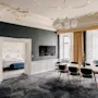 En luksuriøs hotelsuite med spiseplads og udsigt til et soveværelse, med elegant indretning og moderne møbler.