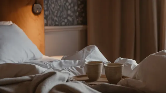 Two cups on a tray on a bed, suggesting a cozy morning or relaxing evening.