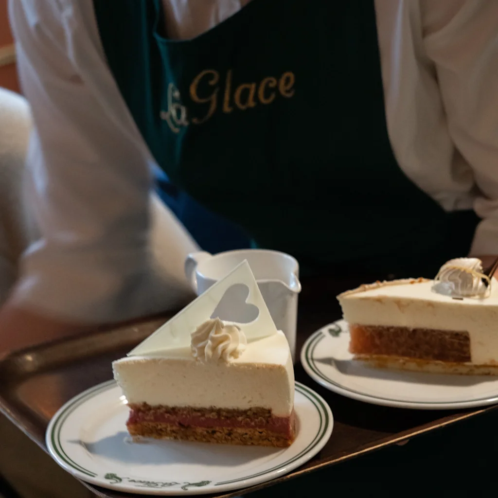 A waiter at Conditori La Glace in Copenhagen serves two exquisite cakes