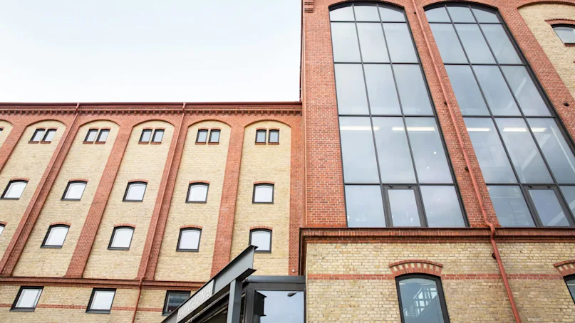 A renovated brick building with large windows under a clear sky.