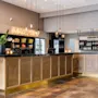 Modern hotel reception and bar in light wood with a glowing Barception sign on the wall.