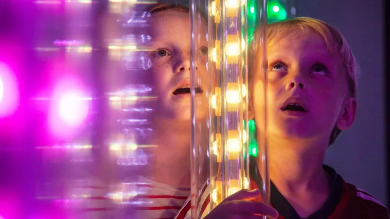 Kids looking at lights in different colors.