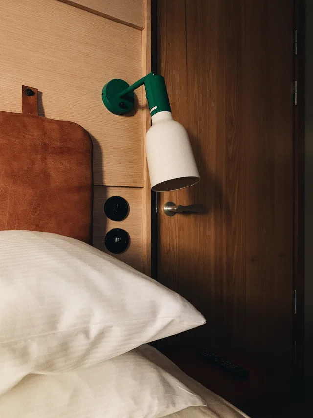 Pillow and lamp beside bed at hotel HOBO in Stockholm.