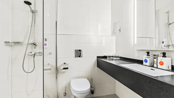 Ett ljust och modernt badrum på Quality Hotel Ulstein, utrustat med dusch, toalett och handfat med bekvämligheter.