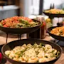 Kutsuva buffet, jossa on erilaisia ​​tuoreita salaatteja, valmiina vieraille nauttimaan terveellisestä ateriasta.