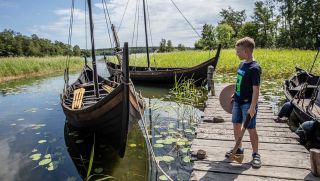 Boy looking at viking ship at Birka. Photo: Claes Helander, Strömma Turism