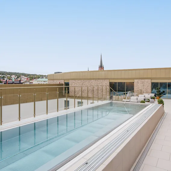 Takpool och loungeområde på Clarion Hotel Sundsvall med utsikt över staden under en klar himmel.