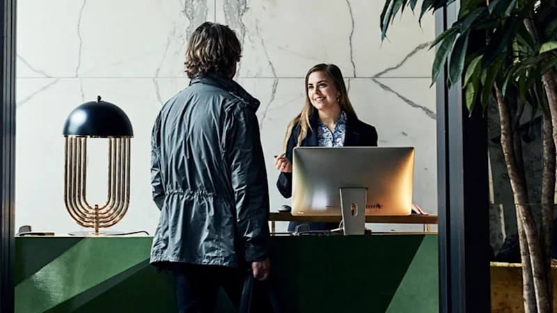 En man checkar in i receptionen på hotell Christiania Teater i Oslo. 