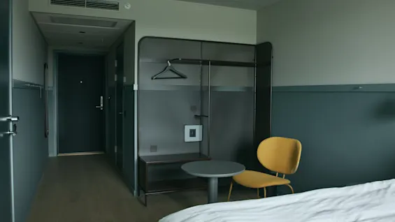 Ett välkomnande hotellrum på Stopover Hotel Falkenberg, designat för komfort med säng, sittplats och förvaringsutrymme.