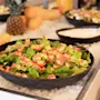 En levende buffetudstilling med en frisk salat med blandede grøntsager og farverige grøntsager, holdt kølig på is.