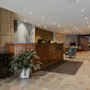 En varm og indbydende hotellobby med en reception i træ, komfortable siddepladser og en hyggelig pejs.