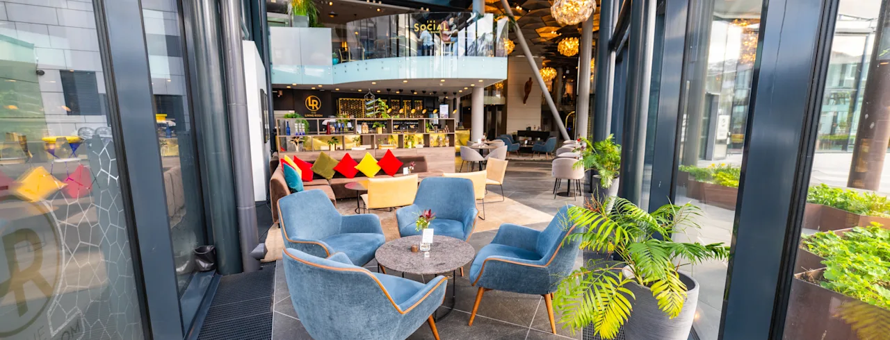 Modern, bright hotel lounge with comfortable seating and glass ceiling at Clarion Hotel The Edge. THE SOCIAL, THE LIVING ROOM.