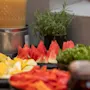 Fresh and colorful buffet at Home Hotel Grand Bodø with sliced watermelon, fruits, salad, and a refreshing drink.